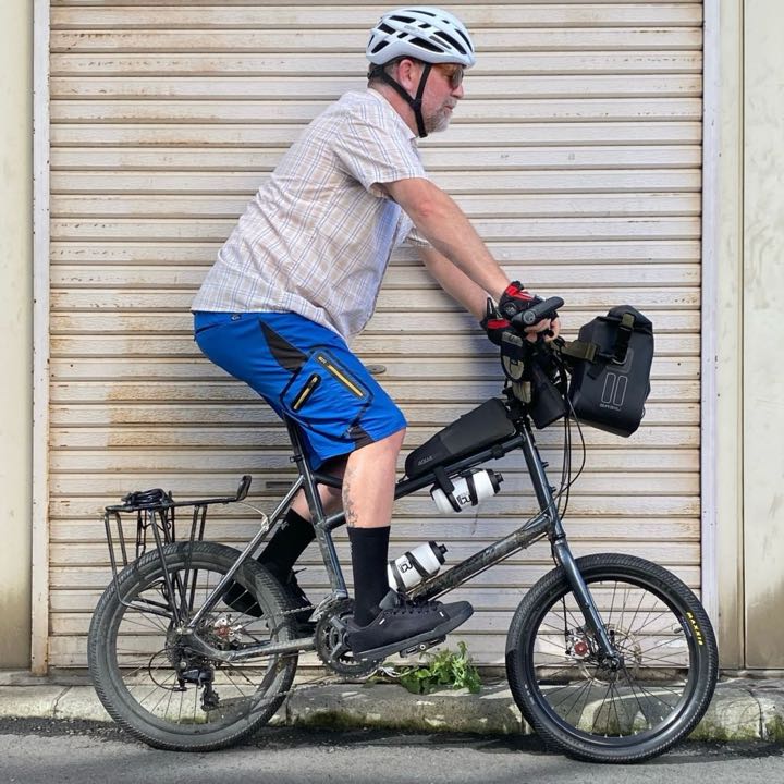 Declan seated upright on a loaded bike, side-on, with pose bones drawn over him.